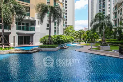 Luxurious condominium pool area with lush greenery and modern architecture.