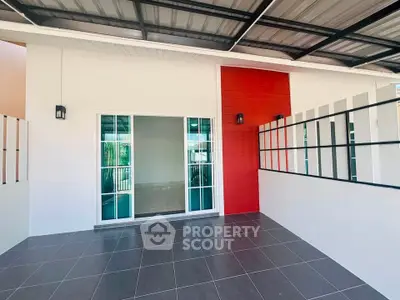 Modern patio with tiled flooring and sliding glass doors, featuring a vibrant red accent wall.