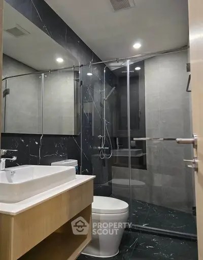 Modern bathroom with sleek design, glass shower, and elegant fixtures in a luxury apartment.