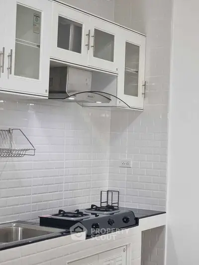 Modern kitchen with sleek white cabinetry and gas stove