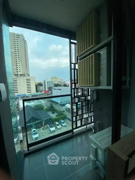 Modern balcony with city view and laundry area in high-rise building.