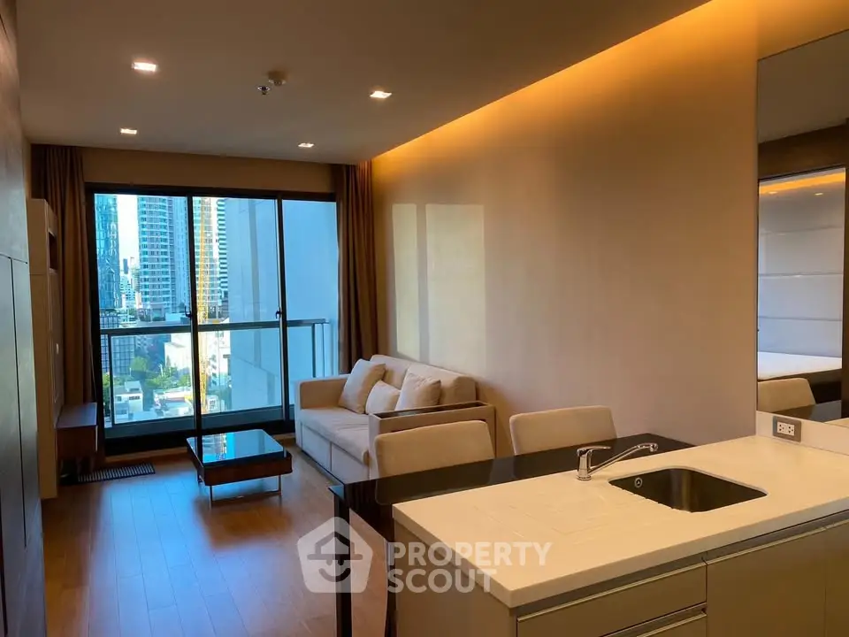 Modern living room with city view, featuring sleek furniture and open kitchen layout.