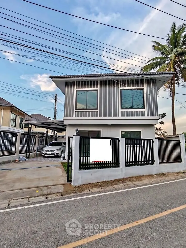 Modern two-story house with sleek design and spacious driveway in a suburban neighborhood.