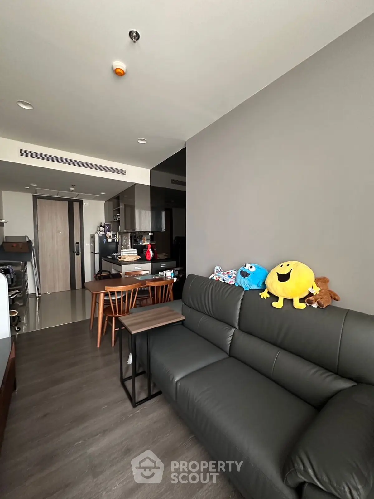 Modern living room with sleek furniture and open kitchen layout in a contemporary apartment.