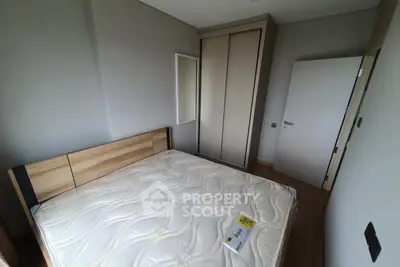 Modern bedroom with wooden flooring and built-in wardrobe, featuring a comfortable bed and minimalist design.