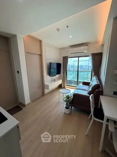 Modern living room with city view, featuring sleek furniture and large windows.