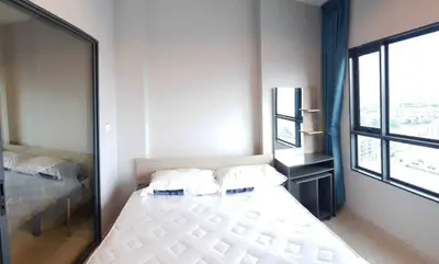 Bright and cozy bedroom with large windows and modern furnishings.