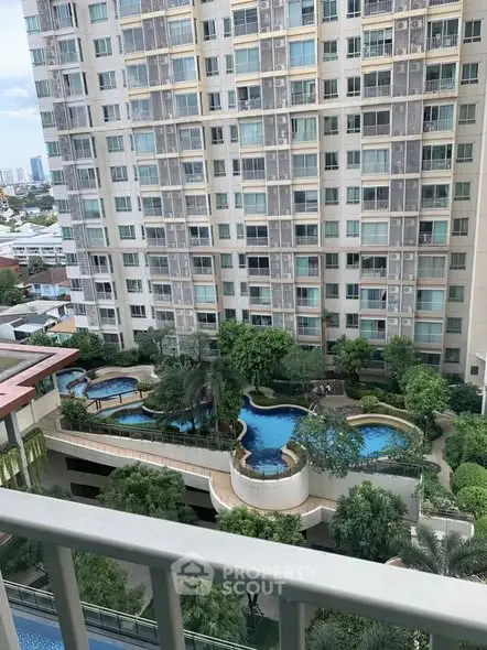 Luxurious high-rise building with stunning pool view and lush greenery