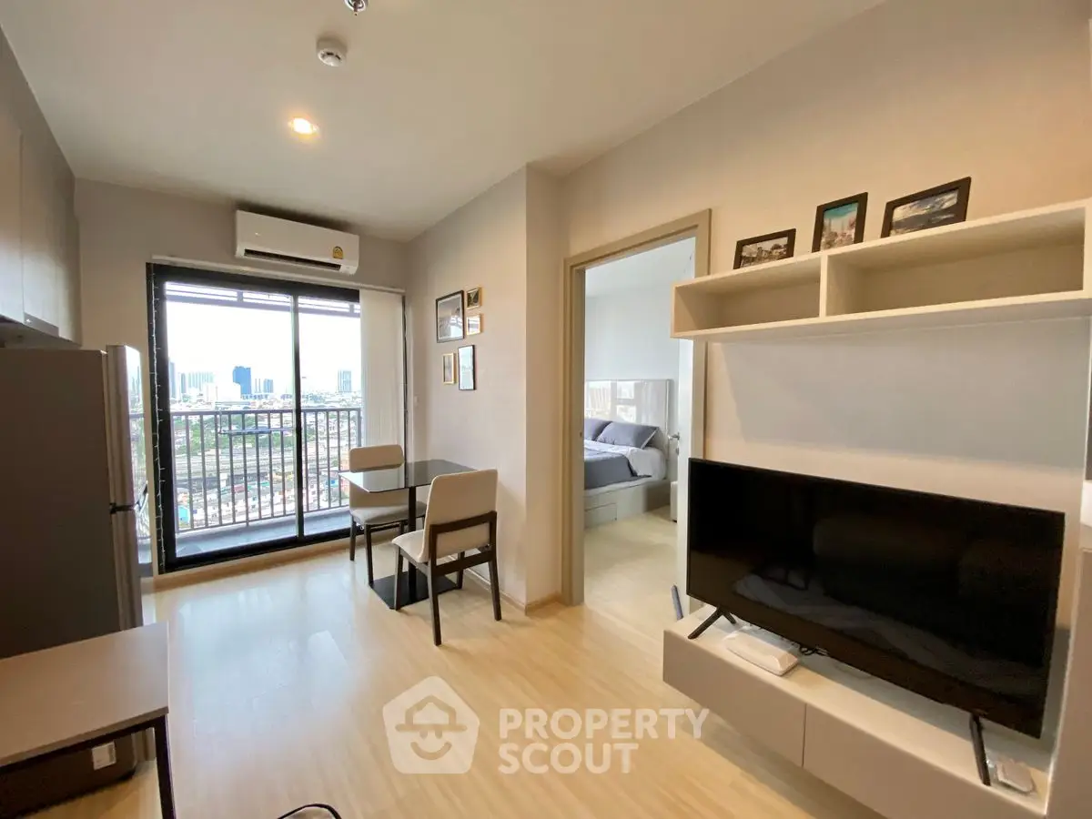 Modern living room with balcony and city view, featuring sleek furniture and open layout.