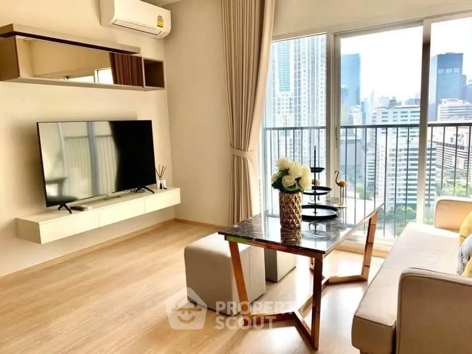 Modern living room with city view, featuring sleek furniture and large windows for natural light.