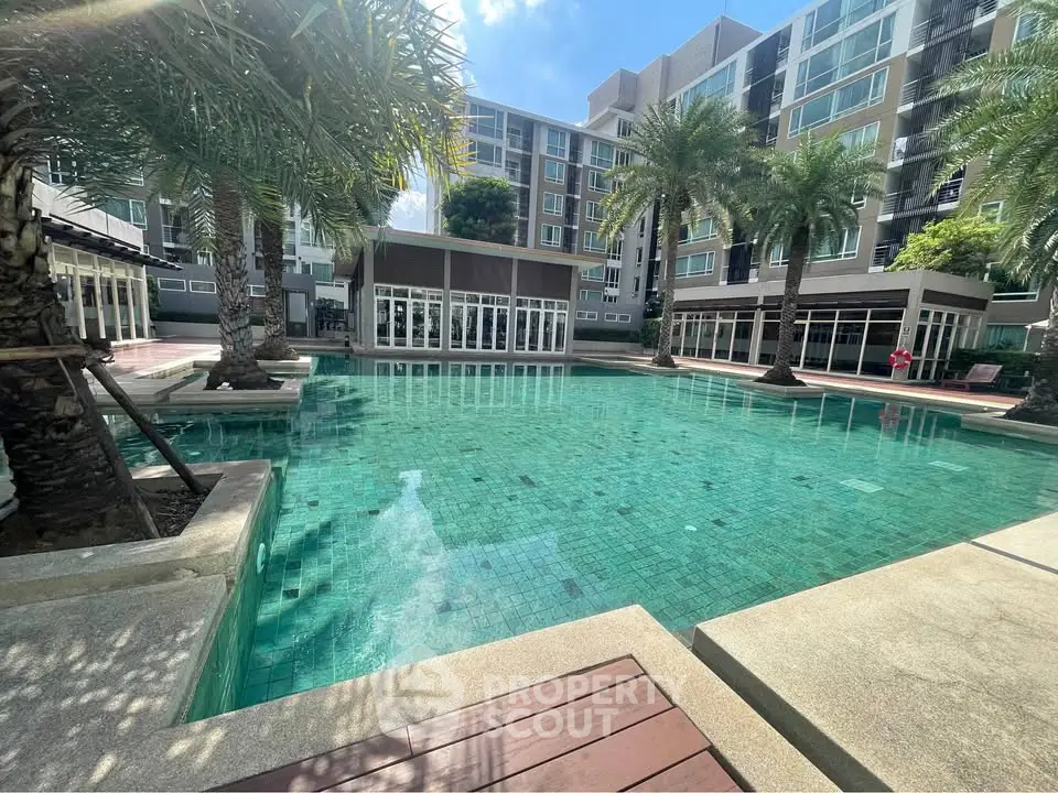 Luxurious condominium with stunning pool and palm trees, perfect for relaxation and leisure.