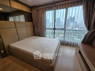 Spacious bedroom with city view and modern decor in high-rise apartment