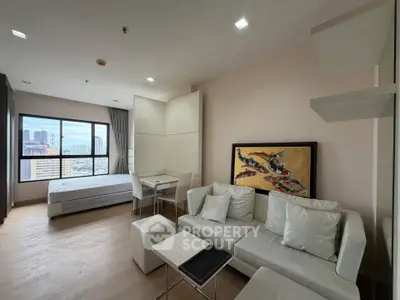Modern studio apartment with city view, featuring a cozy living area and stylish decor.