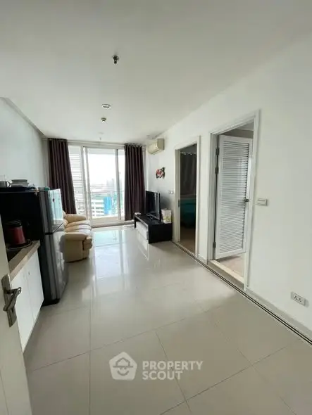 Modern living room with sleek design and large windows offering city views.