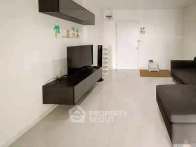 Modern living room with sleek black furniture and white tiled flooring