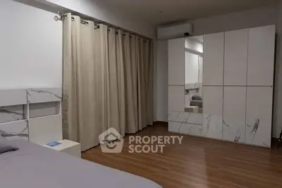 Spacious bedroom with modern wardrobe and elegant curtains, perfect for a cozy retreat.