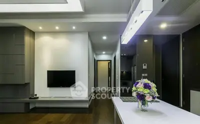 Modern living room with sleek design and elegant lighting, featuring a wall-mounted TV and stylish decor.
