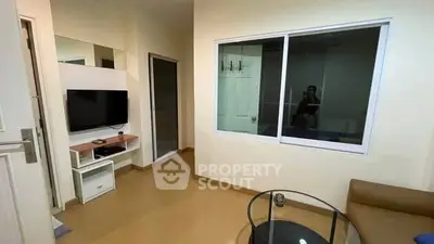 Cozy living room with modern TV setup and glass coffee table.