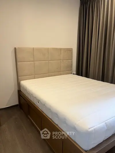 Cozy bedroom with modern bed and elegant curtains, perfect for relaxation.