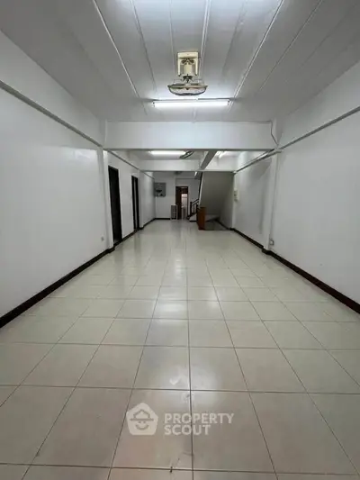 Spacious open-plan interior with tiled flooring and neutral walls, ideal for versatile living arrangements.