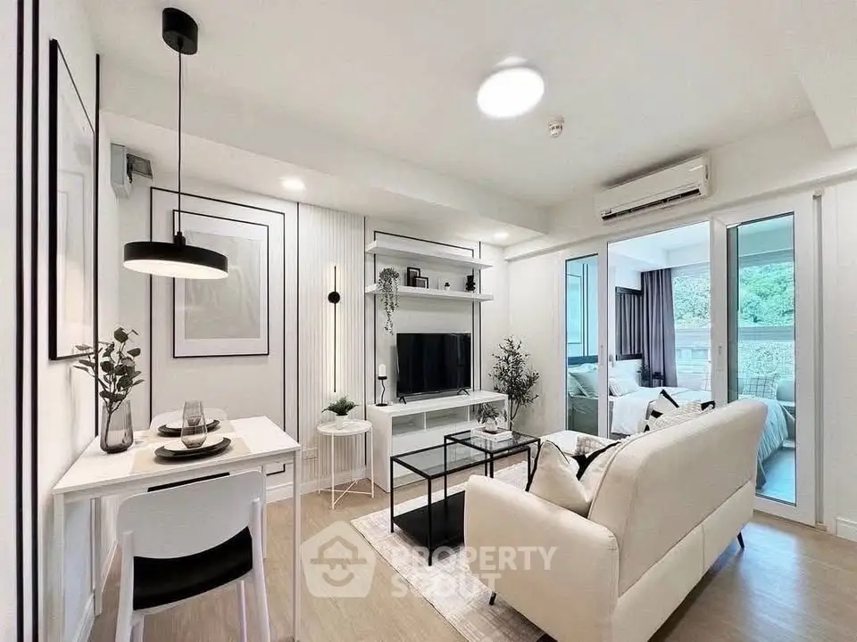 Modern living room with elegant decor and open layout, featuring a cozy dining area and natural light.