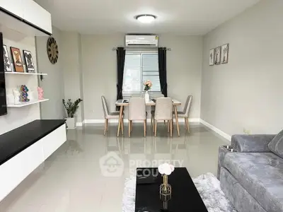 Modern living room with sleek furniture and elegant dining area, featuring neutral tones and stylish decor.