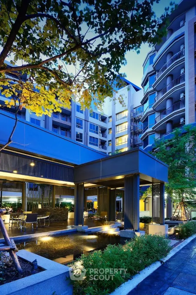 Stunning modern apartment building with lush landscaping and elegant outdoor lighting.