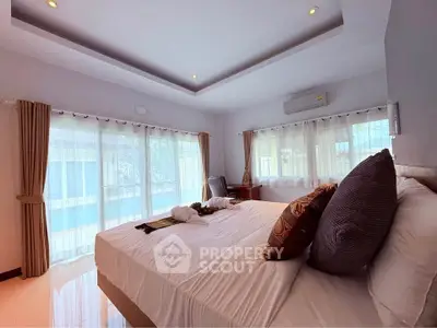 Spacious bedroom with elegant decor and natural light, featuring a cozy bed and stylish curtains.