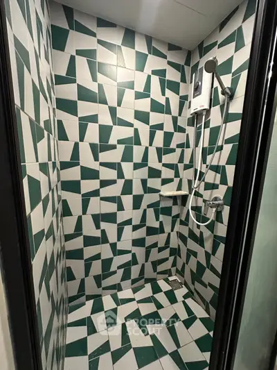 Modern geometric-tiled shower area with sleek fixtures in a contemporary bathroom.