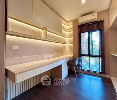 Modern study room with built-in desk and natural light from large window.