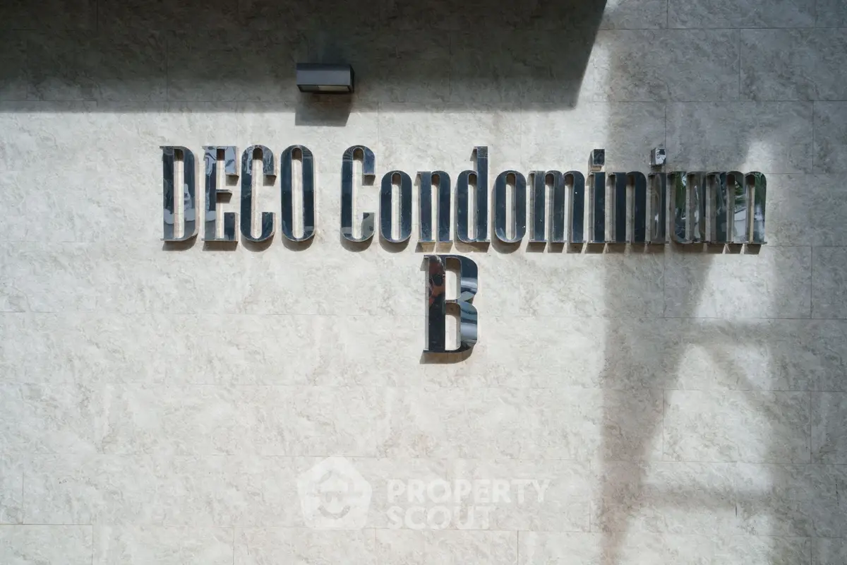 Modern Deco Condominium exterior signage on textured wall