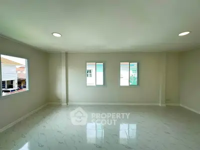 Spacious unfurnished room with large windows and marble flooring in a modern home.
