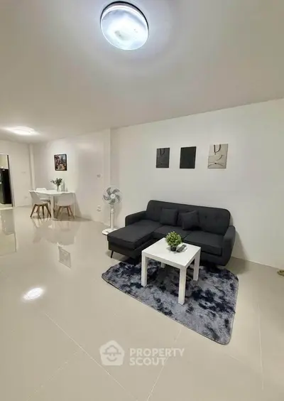 Modern living room with sleek furniture and open dining area, perfect for contemporary living.