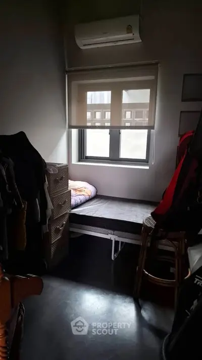 Cozy small bedroom with window and air conditioning unit