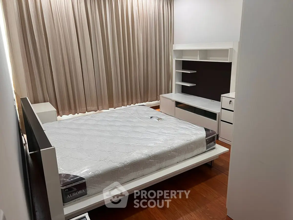 Modern bedroom with sleek furniture and wooden flooring, perfect for a cozy and stylish living space.