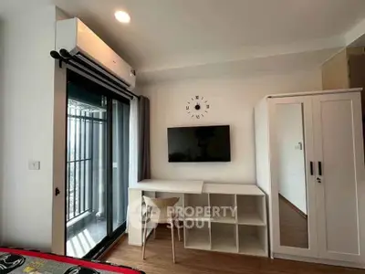 Modern bedroom with balcony access, wall-mounted TV, and sleek furniture design.