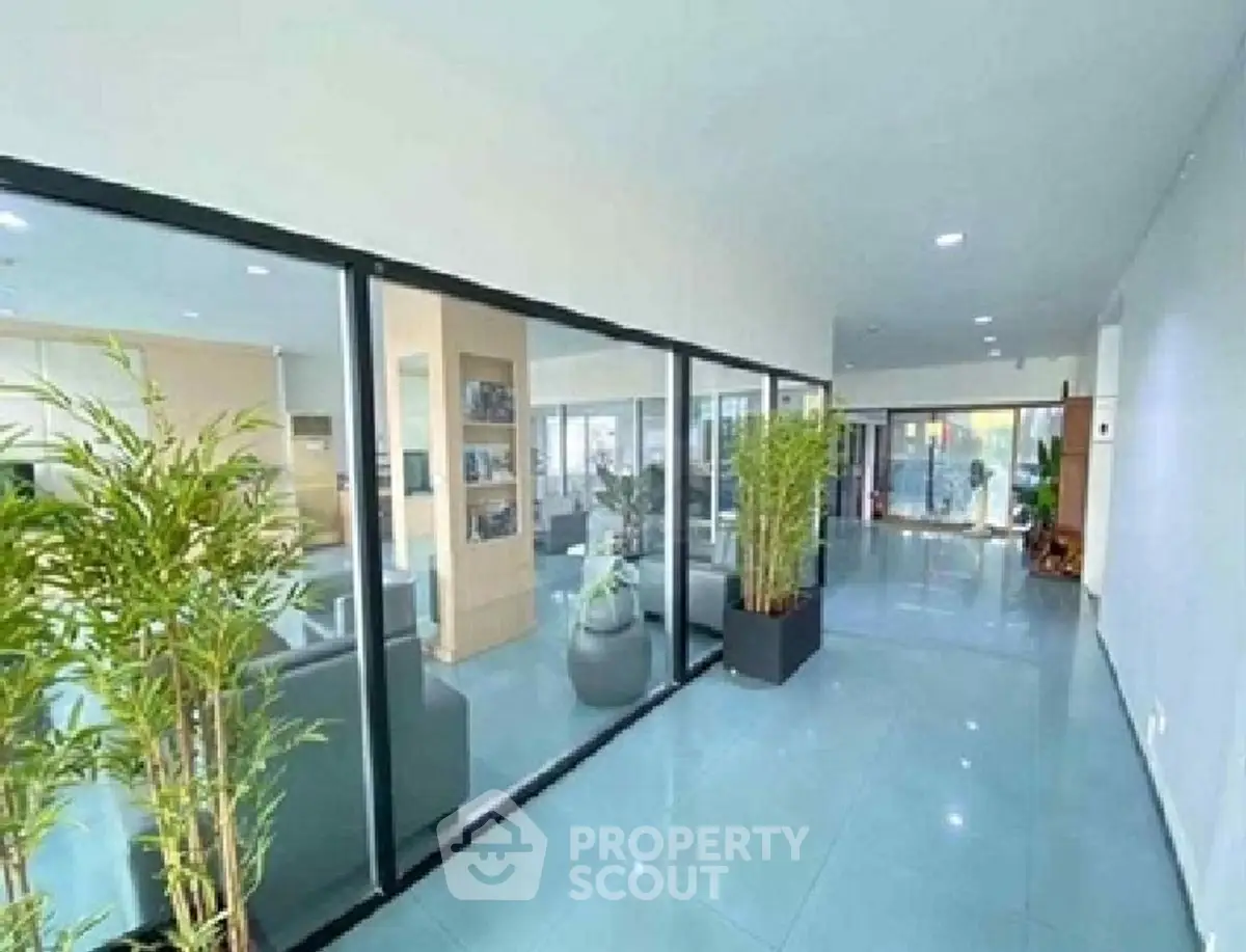 Spacious modern living area with glass partitions and indoor plants