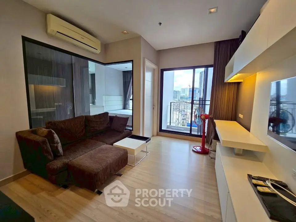 Modern living room with city view, featuring a cozy brown sofa and sleek white shelving.
