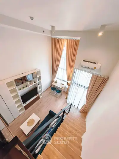Spacious modern living room with high ceilings and elegant decor, featuring a cozy seating area and large windows.