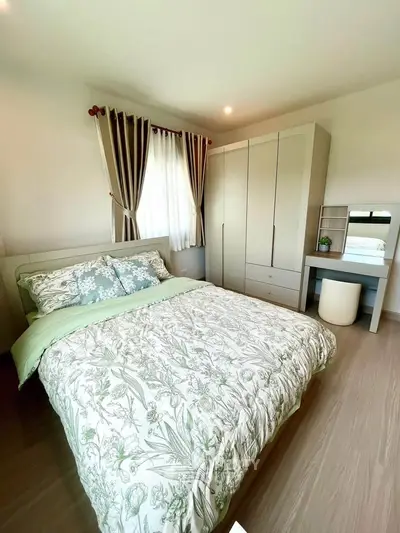 Cozy bedroom with stylish decor and ample natural light, featuring a comfortable bed and modern wardrobe.