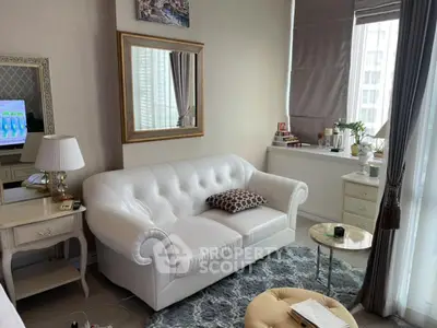 Chic living room with white sofa, elegant decor, and large window view.