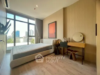 Modern bedroom with large window and city view, featuring stylish furniture and elegant decor.