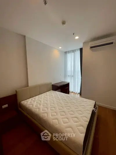 Spacious bedroom with modern furnishings and natural light