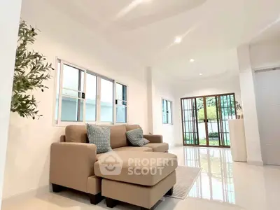 Spacious living room with modern beige sofa and large windows offering natural light.