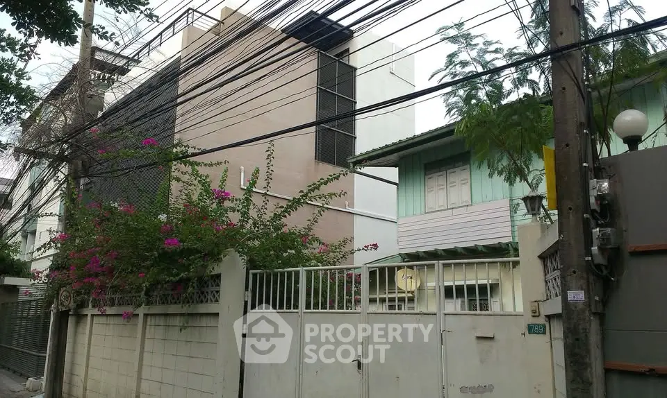Charming urban residential buildings with lush greenery and secure fencing