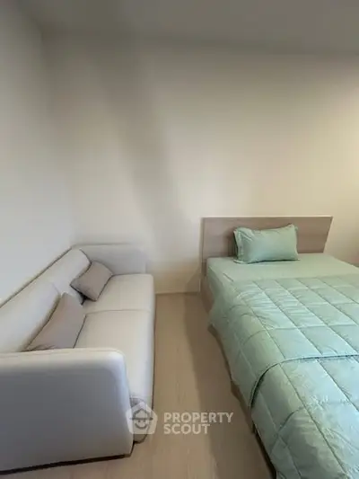 Cozy bedroom with modern bed and sofa, perfect for relaxation.