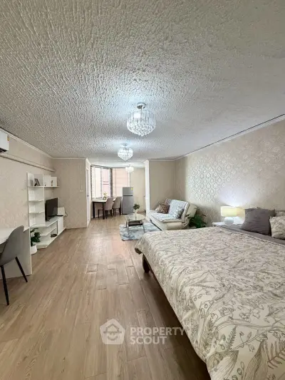 Spacious open-plan living and bedroom area with elegant decor and natural light.