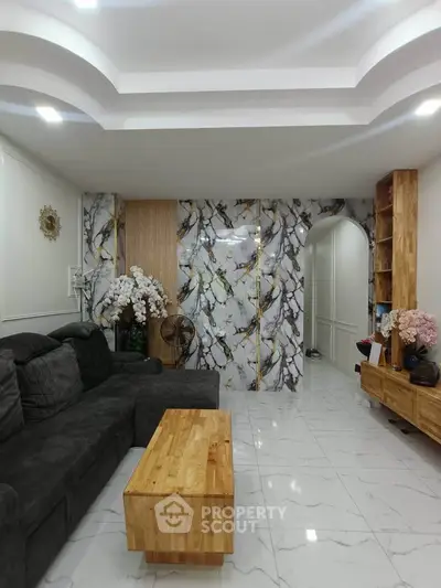 Elegant living room with marble accent wall and modern wooden furniture, perfect for stylish urban living.