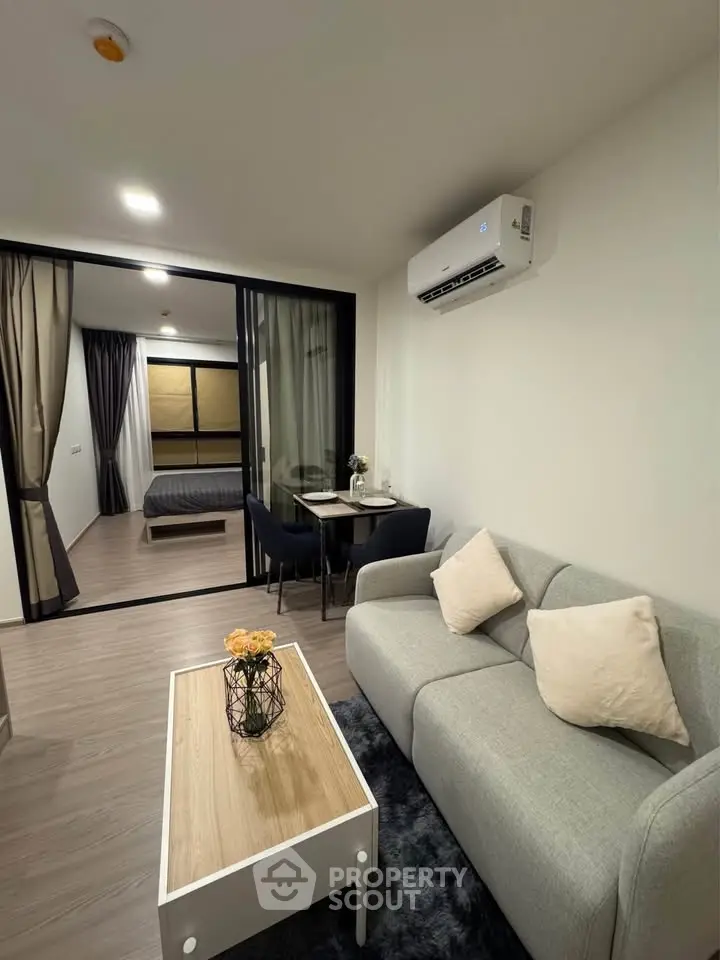Modern living room with cozy sofa and dining area in open-plan apartment