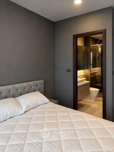 Modern bedroom with ensuite bathroom featuring elegant design and cozy ambiance.